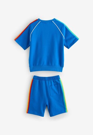 Sinine puuvillane spordikomplekt, millel on lühikeste varrukate ja värviplokkidega topp, samuti elastse vöökohtadega lühikesed püksid, millel on vikerkaare küljeribad ja tasku.