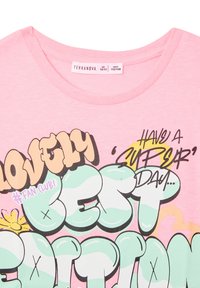 T-shirt rosa a maniche corte con grafica in bold nero e verde pastello, con la scritta "LOVELY" e dettagli "#FAN CLUB", dotato di scollatura rotonda.