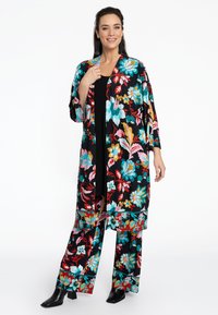 Een met bloemenpatroon versierde kimono en bijpassende broek in het zwart, met levendige blauwe, roze en oranje bloemen. Gladde stof en losse pasvorm.
