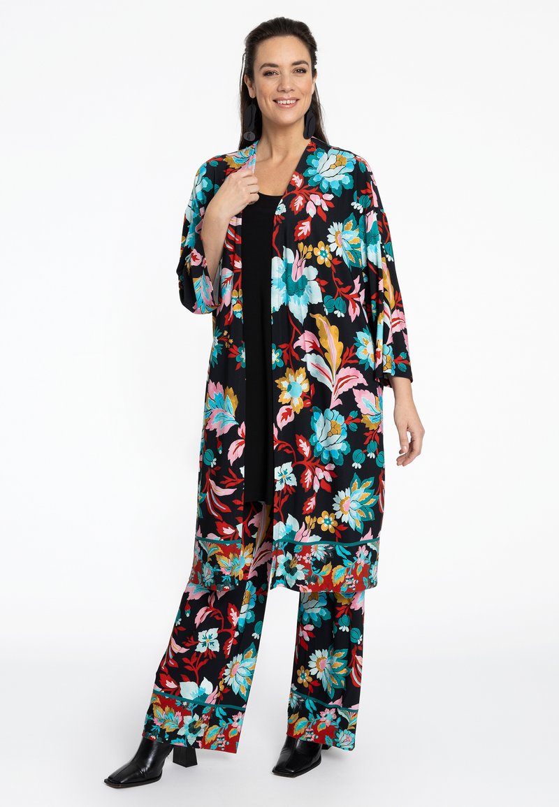 Een met bloemenpatroon versierde kimono en bijpassende broek in het zwart, met levendige blauwe, roze en oranje bloemen. Gladde stof en losse pasvorm.