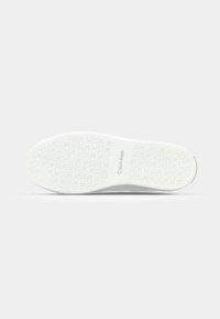 Bijela sneaker potplat s teksturiranim uzorkom, s "Calvin Klein" brendom i kružnim detaljima za prianjanje i grip. Minimalistički dizajn.