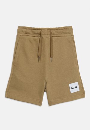 Shorts en coton beige avec ceinture élastique, cordon de serrage, poches latérales et un patch blanc marqué "BOSS" sur la jambe avant gauche.
