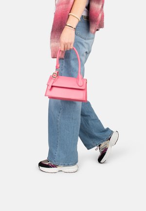 Borsa a tracolla rosa in pelle con design strutturato, manici superiori e patta pieghevole. Indossata con jeans a gamba larga blu chiaro e scarpe sportive.