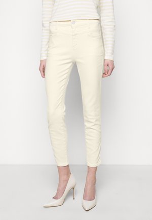 Pantalon en coton jaune clair, ajusté, avec une texture lisse, un design à cinq poches et une fermeture à bouton à la taille.