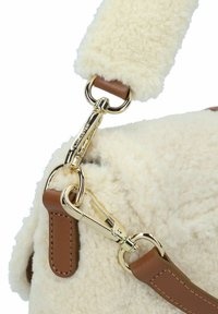 Beige Schaffell-Handtasche mit braunem Lederriemen und goldfarbener Hardware, ausgestattet mit einem Clip- und Ringverschluss. Sanfte Textur deutlich erkennbar.