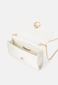 Biała satynowa torebka na ramię z złotym łańcuszkiem, z zamknięciem na pierścień i pojedynczą wewnętrzną przegrodą. Wnętrze ma metkę.