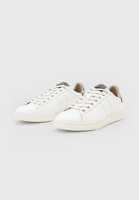 Weiße Leder-Sneaker mit runder Zehenpartie, beigen Schnürsenkeln und strukturiertem Fersendetail. Verfügt über eine flache Gummisohle und ein minimalistisches Design.