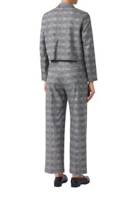 Costume ajusté à carreaux gris avec une veste courte et un pantalon à jambes larges. Le matériau semble texturé ; présente un motif subtil et aucune quincaillerie visible.