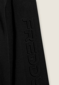 Maglietta a maniche lunghe nera in morbido tessuto, con la scritta in rilievo "FREDDY" lungo la manica, che mette in mostra una texture liscia e un design minimalista.