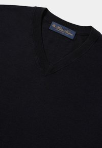 Marineblauwe v-hals trui gemaakt van gebreide stof. Voorzien van een geribbelde halslijn en een merklabel in blauw en goud aan de binnenkant van de kraag.