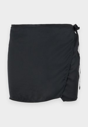 Falda de baño negra con diseño envolvente, hecha de tejido ligero. Cuenta con un cierre lateral con lazo y una textura suave.