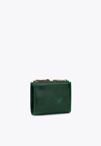 Compact donkergroen leren portemonnee met gouden ritsen op een witte achtergrond.