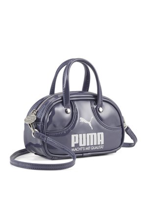 Skinnende lilla mini-håndtaske med tophåndtag, skulderrem og hvidt Puma-logo på siden.