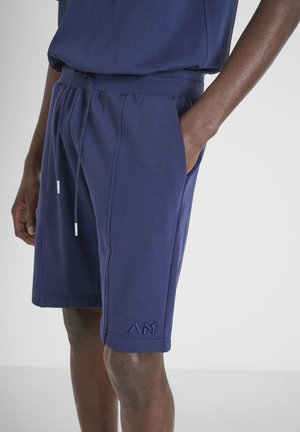 Pantalones cortos azul marino hechos de tela suave, con una cintura elástica con cordón y bolsillos laterales, además de un logo bordado.