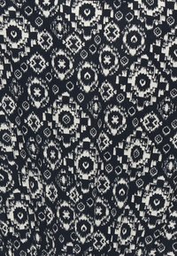 Laine navy dengan pola geometris putih yang menampilkan motif bulat dan bentuk berlian. Teksturnya tampak halus dan ditenun.