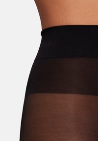 Svart genomskinlig strumpbyxor med en bred, mjuk midja. Materialet är glatt och har en subtil struktur. Perfekt för att lägga under kläder.