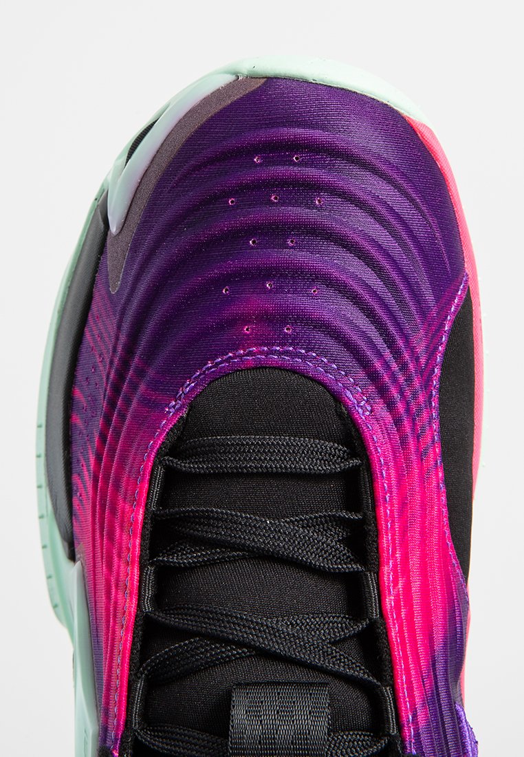 Zapatilla con un diseño degradado en púrpura y rosa, parte superior de tejido negro, superficie texturizada y suela verde menta con cordones negros.