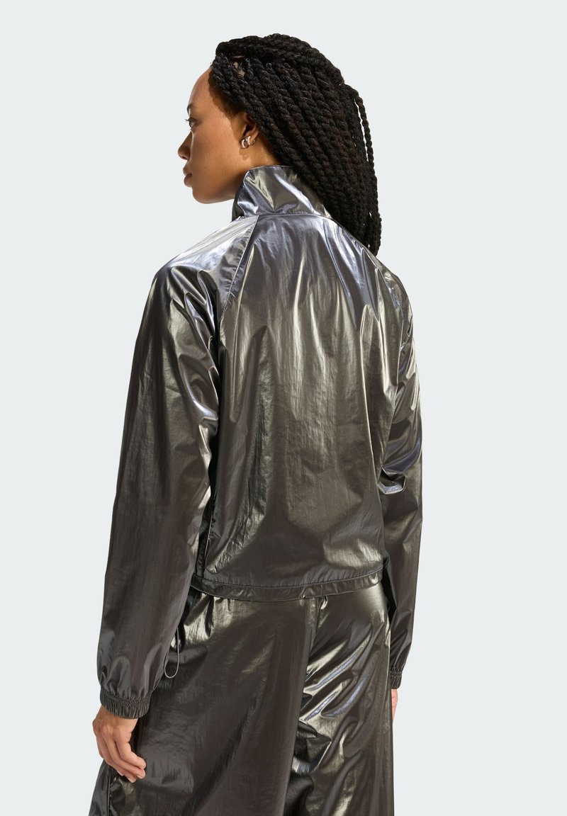 Metallic grey windbreaker jacket with high collar, elastic cuffs, and a smooth texture, featuring a relaxed fit and minimalist design.