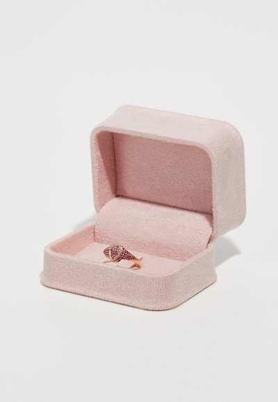 Scatola per anello in velluto rosa con un anello dorato decorato con pietre rosse, esposto su una superficie interna morbida di colore rosa. La scatola ha un coperchio con cerniera.