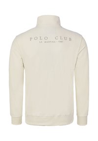 Sudadera tipo polo de manga larga color crema con cuello alto. Presenta un logo sutil "POLO CLUB LA MARTINA 1987" en la parte trasera. Textura suave.