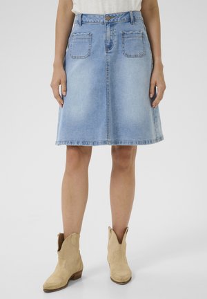 Hellblauen Denim-Rock mit A-Linien-Form, mittellangem Schnitt, zwei hinteren Taschen und einem dezenten, ausgefransten Saum, kombiniert mit beigen Ankle-Boots.