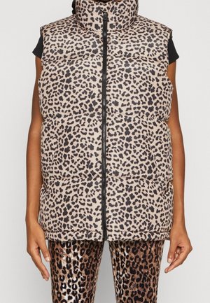 Ærmeløs leopard-print dynejakke med for-lynlås båret over sort kortærmet trøje, kombineret med leopard-print leggings.