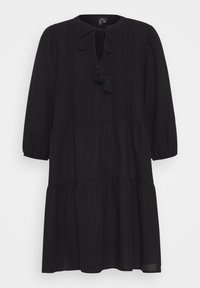 Vestido negro con escote redondo, abertura en forma de llave y acentos de borlas. Presenta mangas abullonadas y un dobladillo escalonado con tela texturizada.