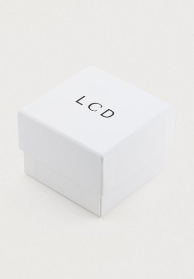Bela kvadratna škatla s pokrovom, na vrhu z črnimi črkami "LCD". Gladek tekstura in čist dizajn.