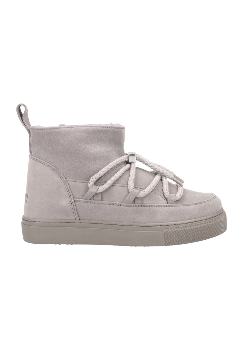 Stivale alla caviglia in suede grigio con suola piatta, caratterizzato da una punta arrotondata, lacci decorativi in corda e una linguetta sul retro. Design minimalista.