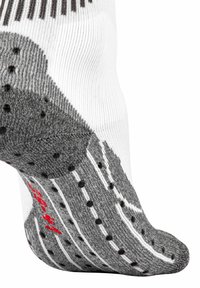 Calzino a fantasia bianco e grigio con texture a coste, impugnatura a puntini sulla suola e dettaglio di branding rosso. Progettato per una calzata sicura.