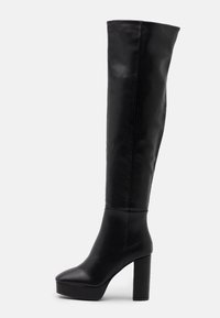 Bottes noires à talons hauts montantes au-dessus du genou en cuir lisse avec un talon bloc et un design à bout arrondi, présentant une tige sans couture et une plateforme.