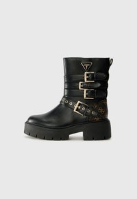 Bottine en cuir noir avec plusieurs boucles en or, côt�és texturés et semelle plateforme épaisse avec un accent décoratif sur le talon.
