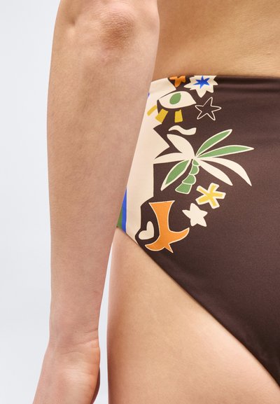 Κοντινό πλάνο σε γοφό και χέρι ατόμου που φοράει μαύρο κάτω μέρος μπικίνι με πολύχρωμα τροπικά και αφηρημένα σχήματα και σύμβολα.