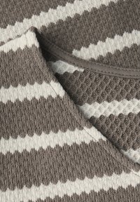 Pletený svetr se střídajícími hnědými a bílými pruhy, s texturovaným vzorem. Výstřih je zaoblený, odhalující měkkou tkaninu.