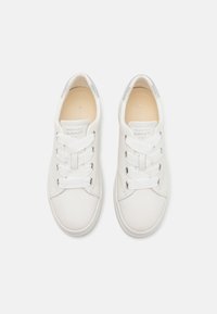 White leather sneakers with silver accents and flat white laces. Smooth texture, rounded toe, minimalistic design, and branded insole.