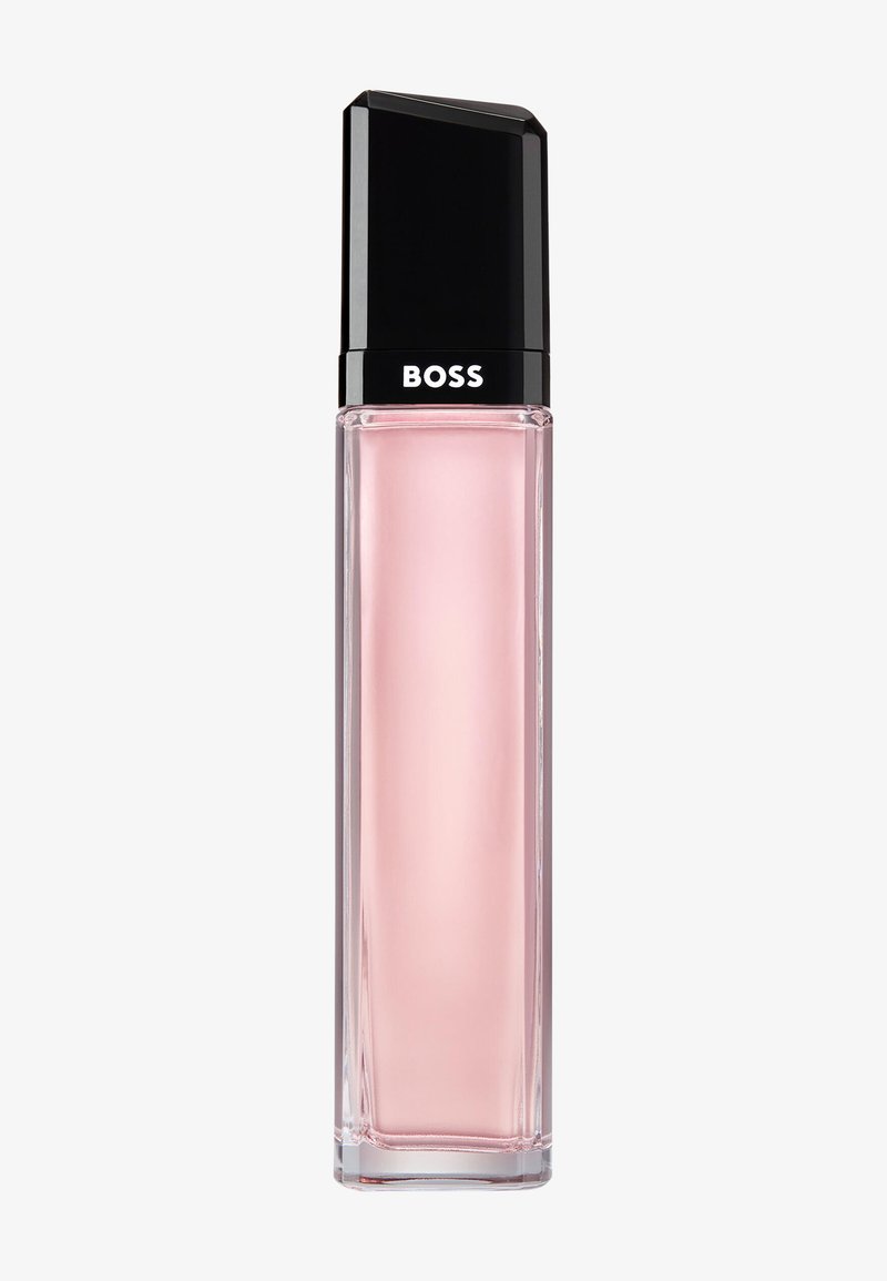 Hoge rechthoekige glazen parfumfles met lichtroze vloeistof, zwarte dop en "BOSS"-logo op de hals.