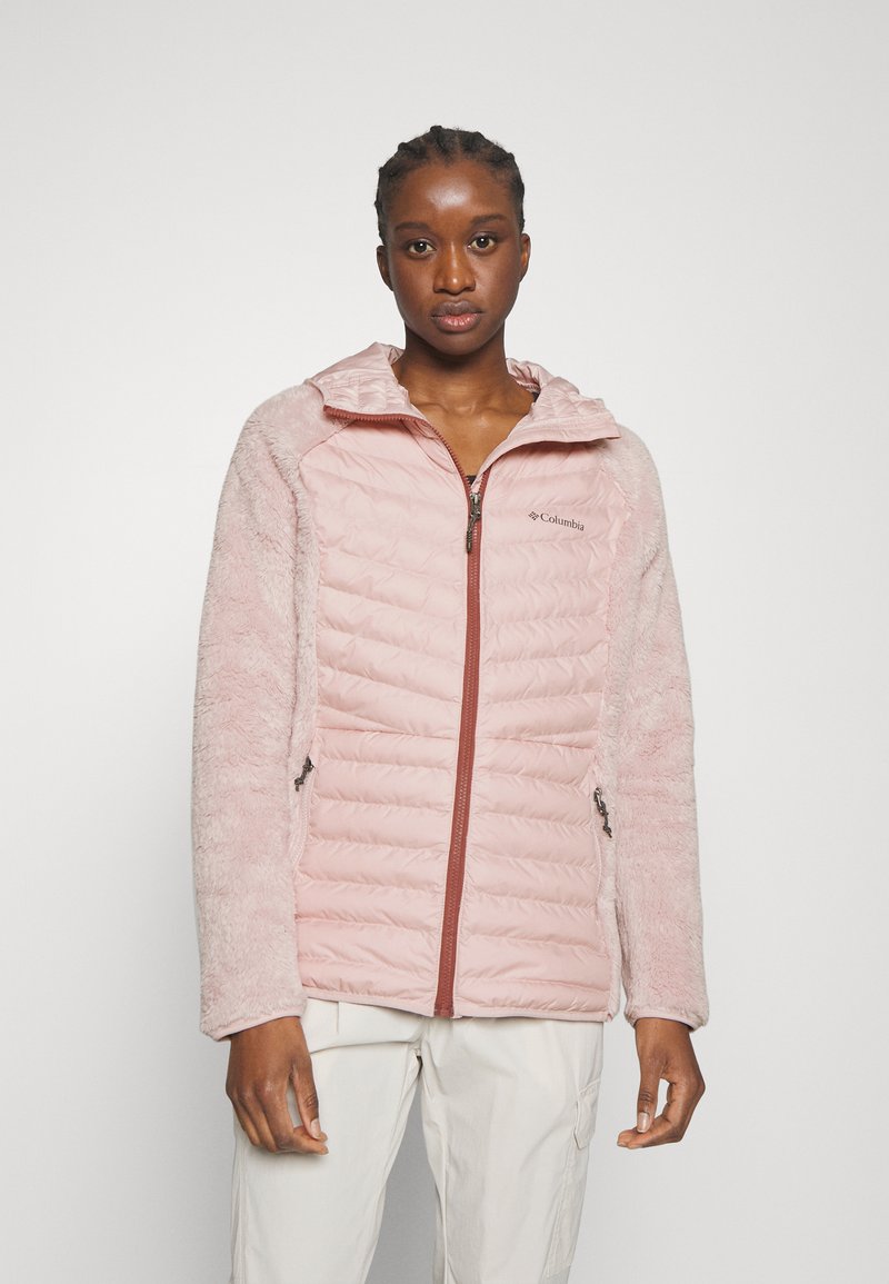 Gepolsterte pinkfarbene Jacke mit flauschigen Ärmeln, ausgestattet mit einem Stehkragen und Reißverschlusstaschen. Logo auf der linken Brust, insgesamt glatte Textur.