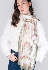 Foulard en soie avec un motif floral dans des couleurs pastel douces et des bords rayés verts. La texture est lisse et légère.