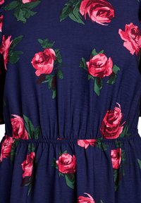 Navy stoffen jurk met een geraffineerde taille, versierd met felroze rozen en groene bladeren in een bloemenpatroon. Zachte textuur en vloeiende ontwerp.
