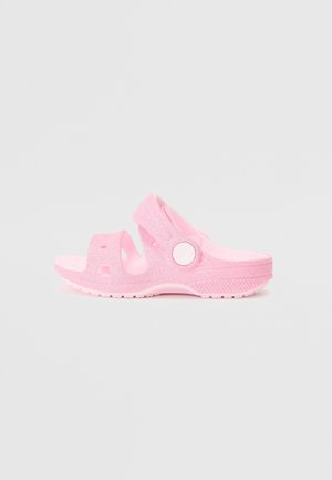 Pink åben tå-sandal med to remme og en bagrem med en rund hvid knap, tekstureret sål og glitrende finish.