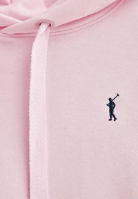 Ljusrosa hoodie med dragsko. Har en liten mörkblå broderad figur som håller en hammare på vänster bröst. Mjuk textur.