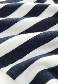 Tessuto a righe navy e bianche, morbido al tatto, in materiale lavorato a maglia, con righe spesse e sottili alternate che creano un aspetto stratificato.