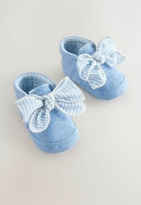 Pantofi din material textil albastru matlasat cu accente mari și dungi în formă de fundă. Căptușeală moale și design cu vârf rotunjit. Potrivit pentru sugari sau copii mici.