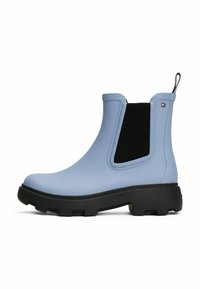 Bottine Chelsea imperméable bleue avec une semelle en caoutchouc texturée, des panneaux latéraux élastiques et une languette de traction. Présente un accent en maille noire.