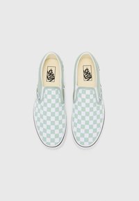 Green and white checkerboard slip-on shoes with a canvas upper, elastic side accents, and a black trim. Vans logo on the insole.