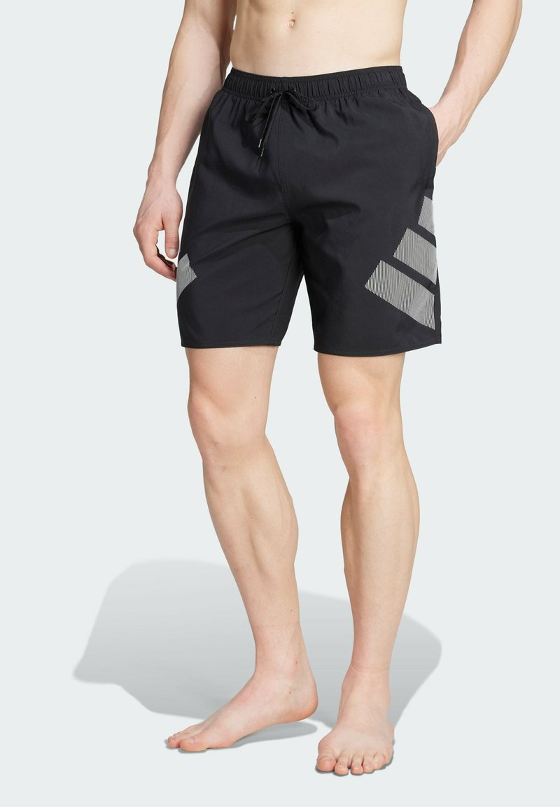 Bañador negro con cinturilla elástica y cordón, detalles diagonales grises y una tela ligera y suave.