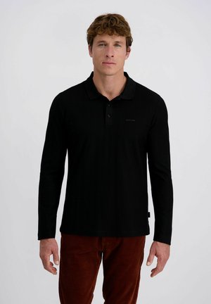 Zwart long-sleeve polo shirt gemaakt van zachte stof, met een kraag, knoopsluiting en een klein logo detail op de borst. Gepaard met bruine corduroy broeken.
