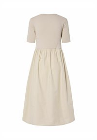 Bežna haljina s pripijenim gornjim dijelom i lepršavom, nabranom suknjom. Izrađena od mekanog materijala s kratkim rukavima i okruglim izrezom.