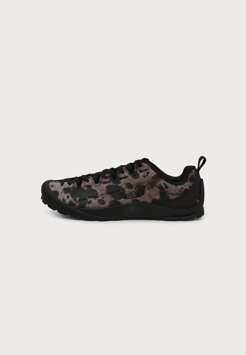 Chaussure de sport basse imprimé léopard noir et gris avec semelle noire, lacets noirs et languette au talon.