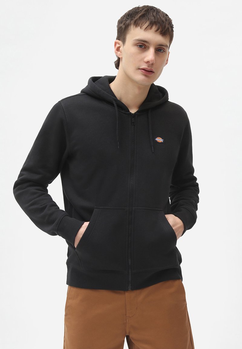 Sort zip-up hoodie lavet af fleece, med en front kangaroo lomme, justerbar snøre i hætten og et lille logo på brystet.